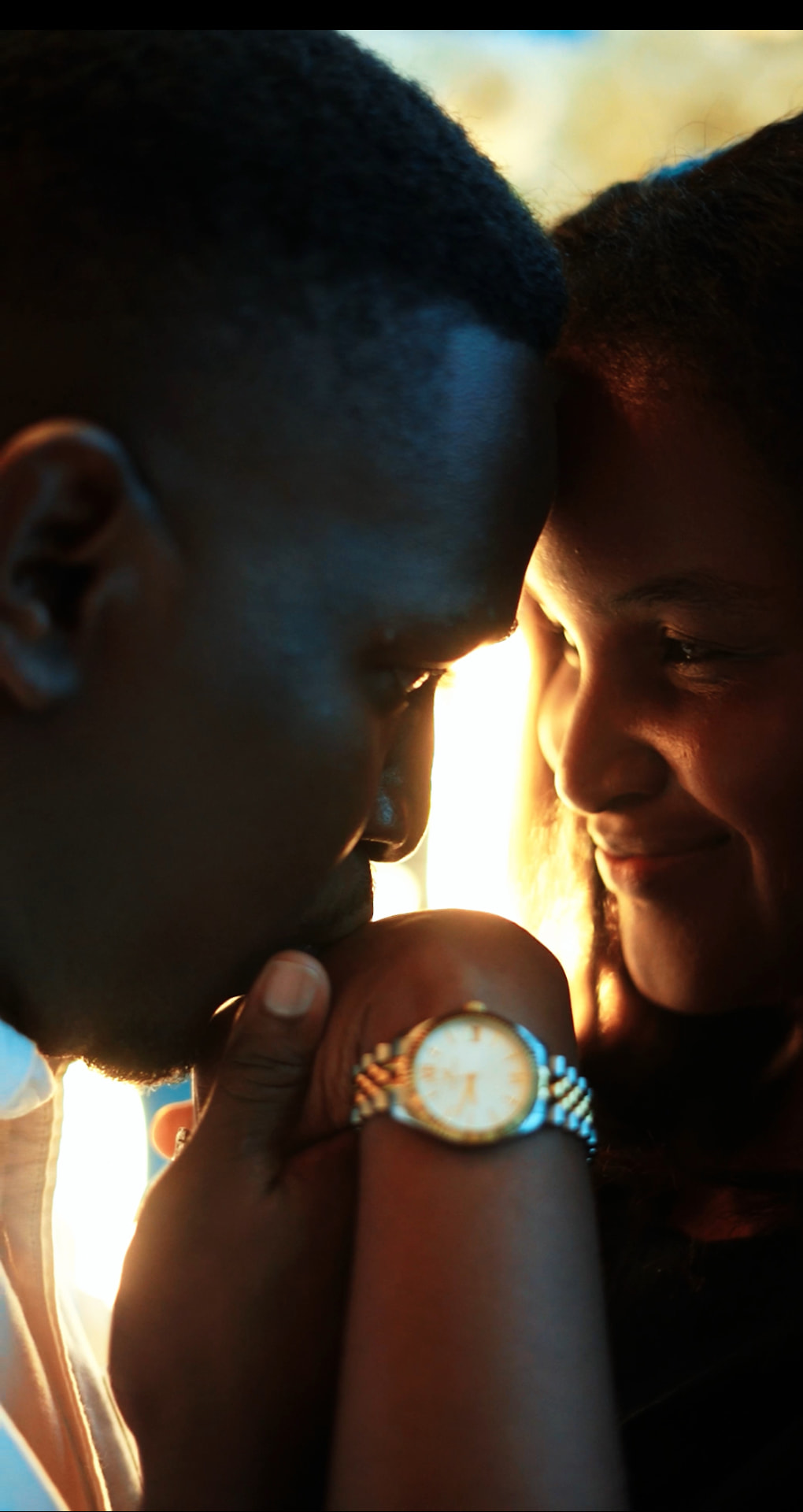 Emmanuel kissing Martha's hand in golden sunlight