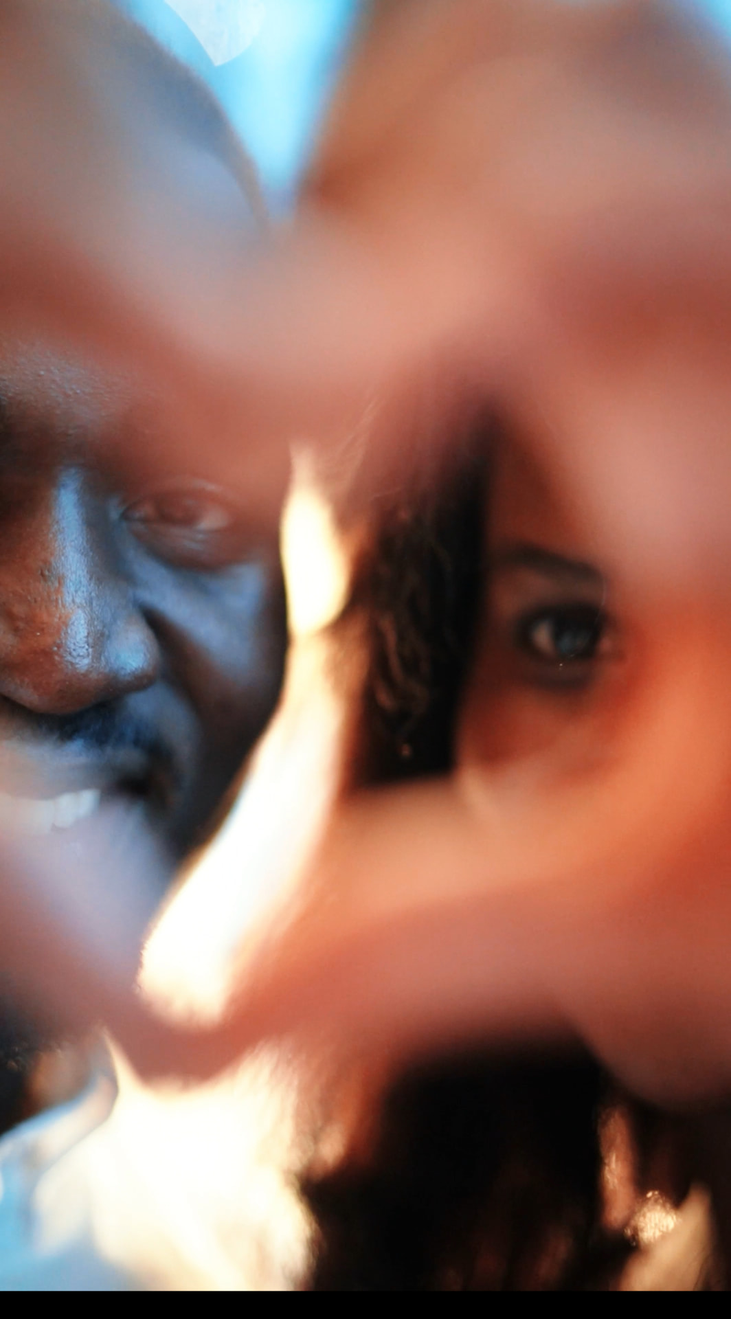 Emmanuel and Martha framing each other with their hands