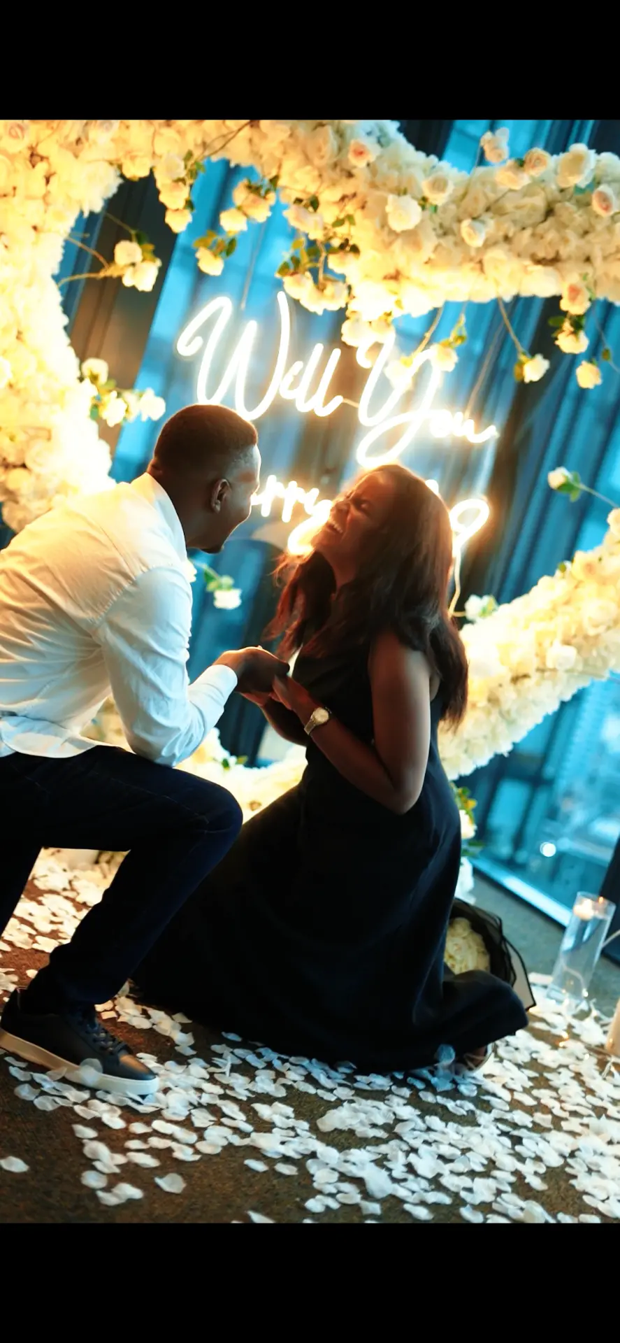Emmanuel proposing to Martha under a heart of white roses